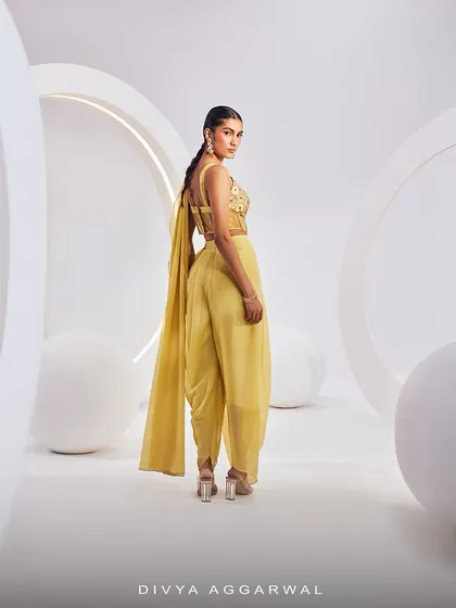 The back view of our ISLA Saree Set, showing the unique dhoti-style pre-draped saree and the detailed corset blouse in a cheerful yellow.