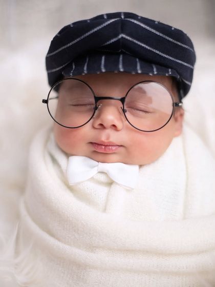 A dapper little gentleman! This close-up shot highlights the adorable details of this themed pose, from the tiny white bowtie to the round glasses.