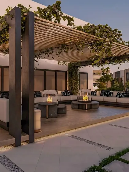 This outdoor lounge in Noida is defined by its striking modern pergola, draped with climbing vines. We designed the space with expansive, comfortable seating and central fire pits, making it an inviting hub for social gatherings day or night.