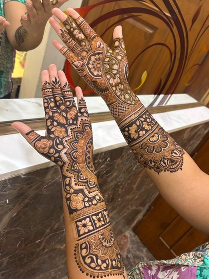 A beautiful mirror shot of a client's finished mehandi, showing both the front and back designs.