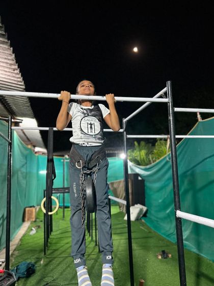 Reaching for the moon, literally. A powerful weighted pull-up under the night sky shows the dedication of our athletes, training anytime to get stronger.