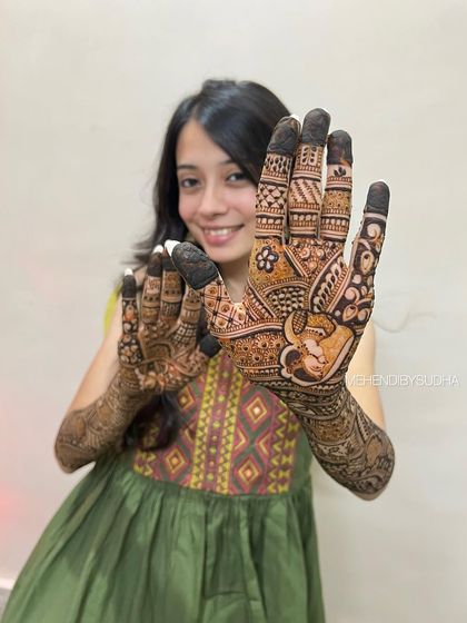 This pose highlights the intricate bride figure drawn on the palm, a central part of her story.