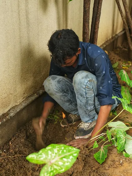 Getting our hands dirty is part of the job. Here, a team member prepares the soil for planting Caladiums.