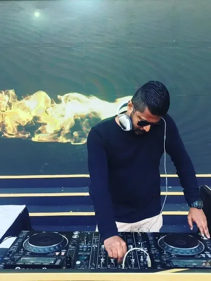 A clear shot of me at my outdoor setup, fully focused on the mix. I use a Pioneer DDJ controller, a standard for professional mobile DJs, ensuring reliability and great sound quality.