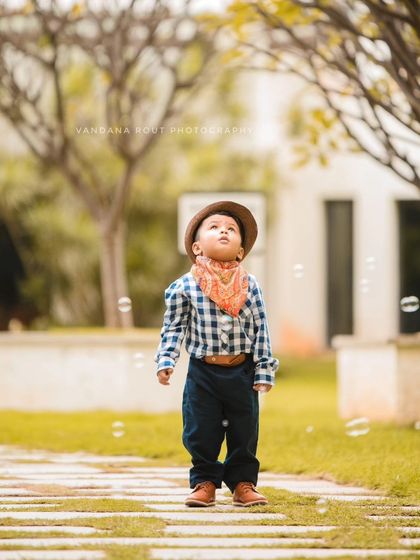 A toddler looks up in wonder at floating bubbles during an outdoor shoot. This is a perfect example of a candid moment that captures the magic of childhood.