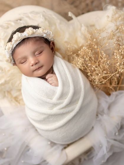 Pure love in a heart. This angelic newborn portrait, with soft white textures and dried flowers, is all about innocence and tenderness.