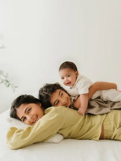 A fun and playful "sibling pile" with the baby brother on top. This shot is full of laughter and captures the fun of having siblings.