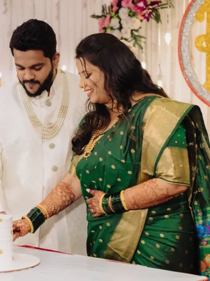 A candid moment during the engagement cake-cutting ceremony. The bride's makeup is flawless and long-lasting, keeping her looking fresh throughout the event.