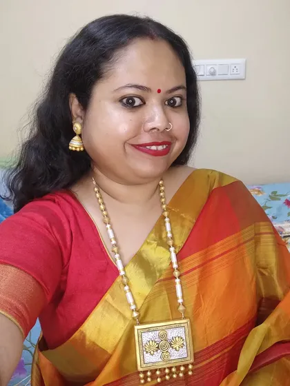 A selfie of me wearing my elegant dual-tone lotus necklace. The long style is very graceful, and the gold and silver tones make it versatile.