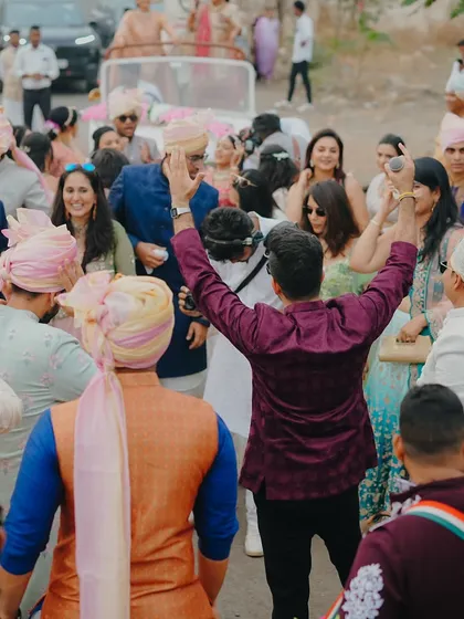 A view from behind, showing me leading the entire baraat procession in a dance. I love getting everyone to join in the celebration.