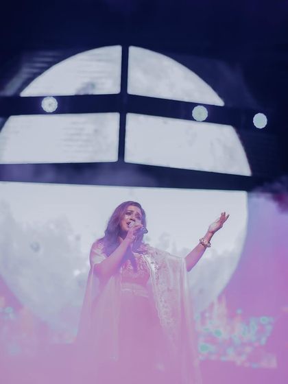 Shreya Ghoshal performing in front of a stunning moon backdrop at Tathva, NIT Calicut. Our team designs creative and visually impressive stage setups for our artists.