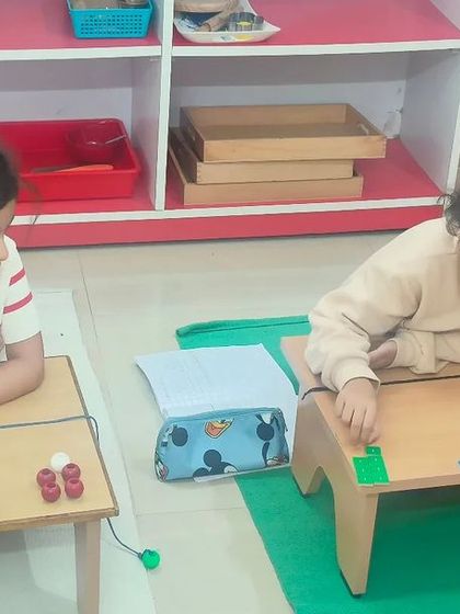 This is the magic of a mixed-age group environment. A younger child observes an older child working on a complex subtraction problem, naturally absorbing the process and preparing herself for when she is ready for the same lesson.