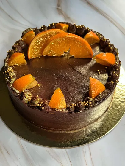 A close-up of the rich chocolate and orange decoration on our popular boozy cake, finished with a sprinkle of gold for a touch of luxury.