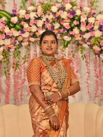 A grand entrance for the reception. This bride looks regal against the floral backdrop, her elaborate jewellery and rich saree making a stunning statement.