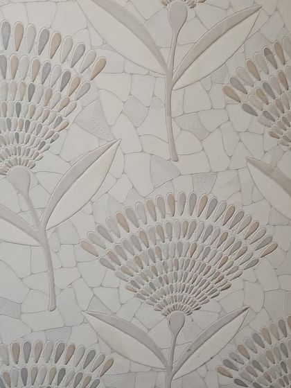 An intricate floral mosaic tile. The delicate pattern is created with small, individually placed stone pieces, offering a subtle and sophisticated texture.