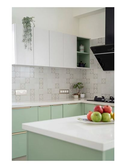 A detail of the kitchen backsplash, where subtle printed tiles are interspersed with plain handmade tiles. This arrangement enhances the kitchen's aesthetic with a sense of crafted simplicity.