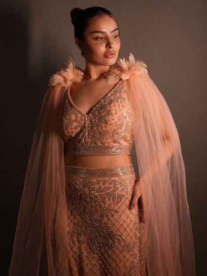 A full view of the stunning peach cape set, showcasing its elegant silhouette and glamorous details. Rent this luxury look with Mohraya.