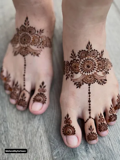 Mehendi for the feet completes a festive look. This elegant design features a central motif connected to detailed patterns on the toes, like beautiful, delicate jewelry for your feet.