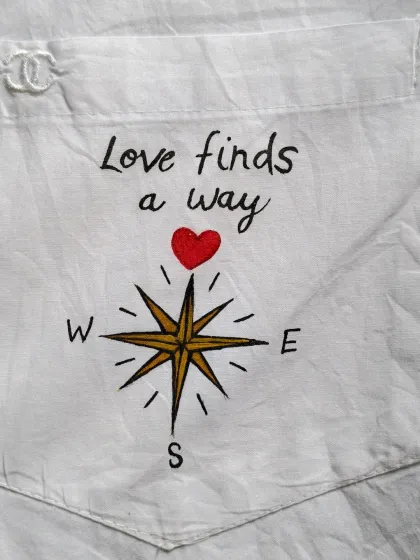 On the pocket of the same anniversary shirt, I painted this "Love finds a way" compass. It's a small detail that adds a lot of meaning to the overall story of the custom apparel.