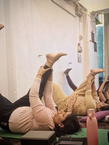 A group of students practicing a supported leg stretch to improve hamstring flexibility.