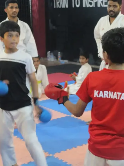 A young student spars during his belt grading test. These controlled fights are essential for testing a student's reflexes, control, and application of techniques under pressure.
