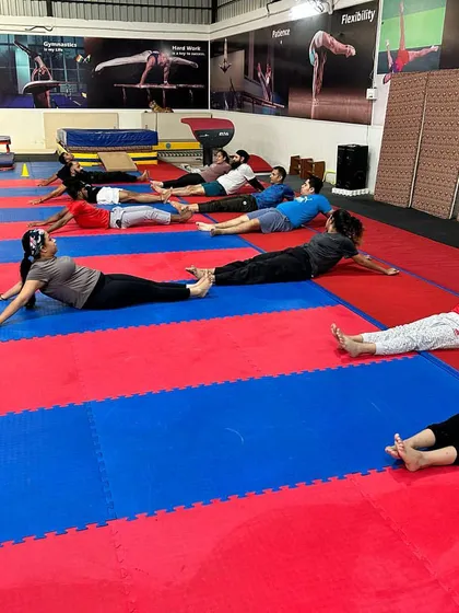 A group of students works on back and shoulder flexibility with a floor exercise. Consistent mobility work is a key part of our program to improve posture and prevent injuries.