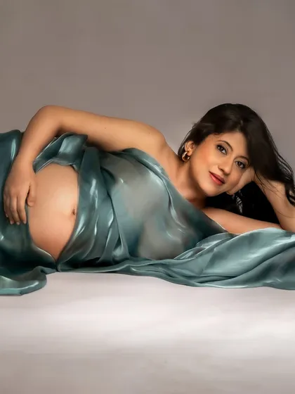 A sensual and artistic pose using a shimmering teal drape. This shows how we can play with fabric to create unique and stunning images.