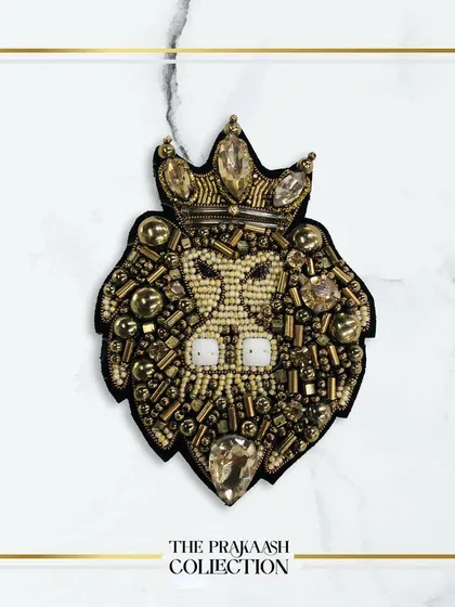 This hand-embroidered patch showcases a majestic lion's head with a crown, crafted with beads, stones, and metallic thread. It's a statement appliqué designed to add a regal touch to blazers, jackets, or bags.