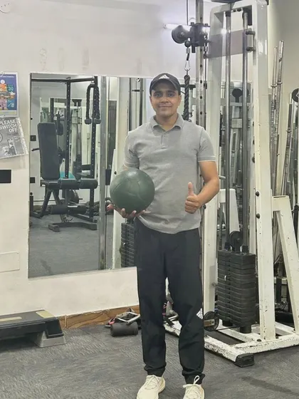 Holding a medicine ball at the gym in Noida Sector 50. This is a great tool for functional strength training.