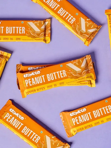 A dynamic arrangement of peanut butter wafer bars on a solid background. The overlapping and angled placement creates a sense of energy and abundance.