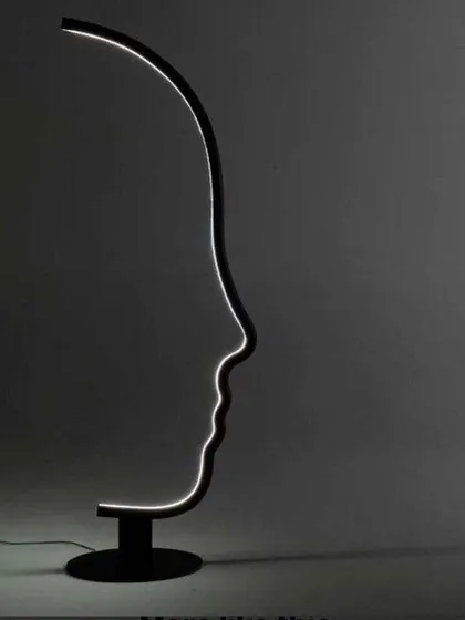 Even when dimmed, the strong graphic shape of our face profile lamp stands as a piece of modern sculpture. The black painted wood structure and solid metal base ensure it remains a recognizable and artistic element in your room.