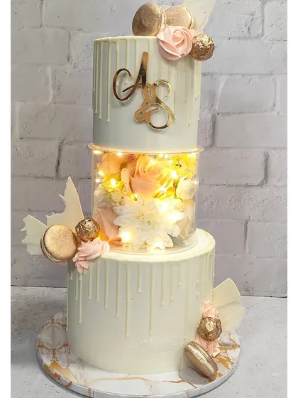Welcome! I believe every celebration deserves a showstopper. This three-tiered cake, with its glowing LED lights and delicate white chocolate drip, is an example of how we can make your special day truly shine. I love taking a classic design and adding a modern, memorable twist.