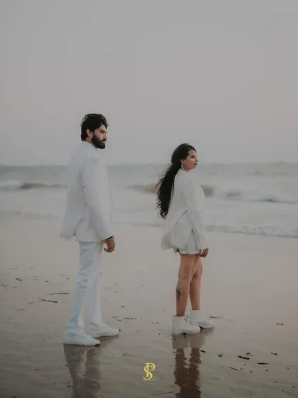 A cinematic, wide-angle shot of the couple on the beach. This captures the vastness of the ocean and the feeling of them being in their own world.