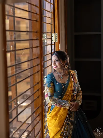 A portrait capturing the feeling of a dream realized. Here, the homeowner looks out from her new home during the Gruha Pravesha, dressed in a stunning traditional outfit.