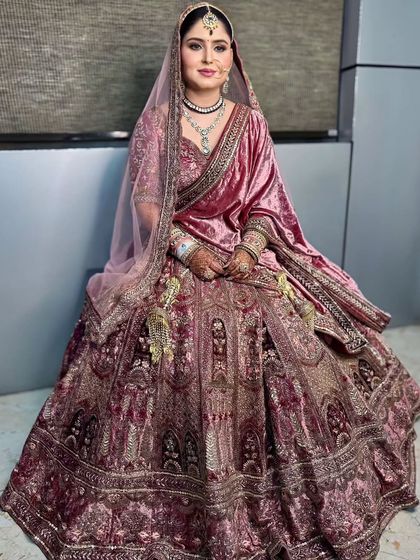 A full-length portrait of the bride, looking regal in her velvet outfit.