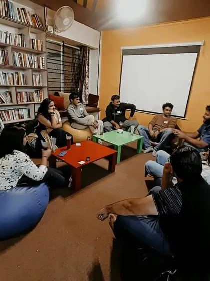A group of friends enjoying a game of Mafia in our cozy library corner, surrounded by books and comfortable bean bags.