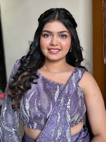 The full look, showing how the purple eyeshadow and soft waves create a cohesive and glamorous style.