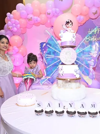 The full dessert table for the butterfly party, with the tiered cake, cupcakes, and other treats all beautifully arranged.