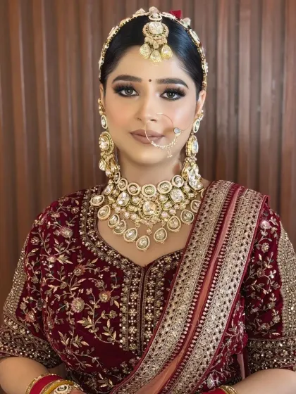 A confident bride looking directly at the camera. Her makeup is clean and defined, with perfectly shaped brows and a neutral lip color that enhances her features.