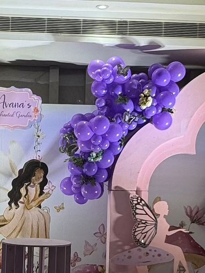 A purple balloon cluster attached to the main backdrop arch.