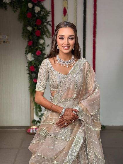 A full-length view of the engagement look. The soft, open hairstyle complements the delicate and shimmery lehenga perfectly.
