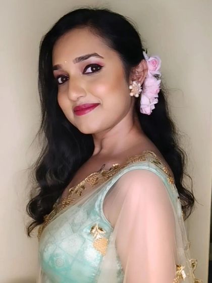 A portrait of this elegant look, with soft curls and a fresh flower in her hair.