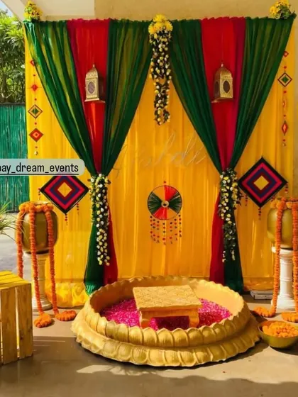 A beautiful and functional Haldi setup with a central urli for the ceremony, framed by colorful drapes and traditional decor elements.
