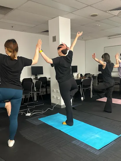 Demonstrating proper alignment and posture during a standing pose. Even small adjustments can make a big difference in how you feel. My goal is to ensure everyone feels comfortable and supported in my workplace yoga classes.