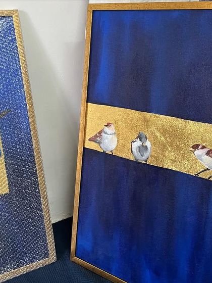 A pair of my bird paintings, framed and ready to be hung. One features blue jays, and the other sparrows, showing a cohesive series that can be displayed together or separately.
