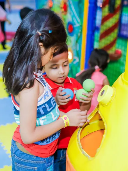 Kids working together at one of our interactive ball play stations during a special offer period.