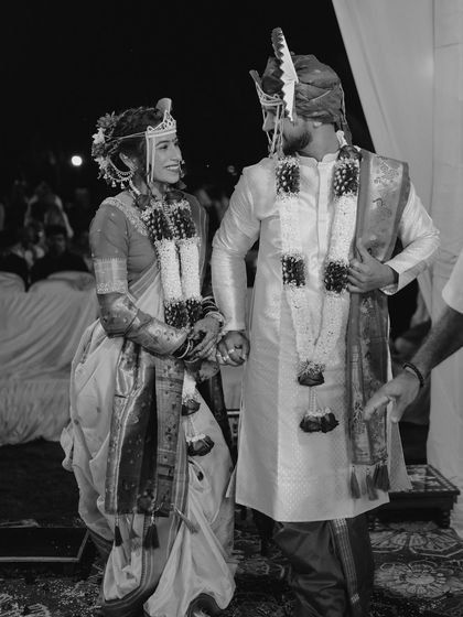 A timeless black and white photograph of the couple on their wedding stage, capturing a quiet, shared glance.