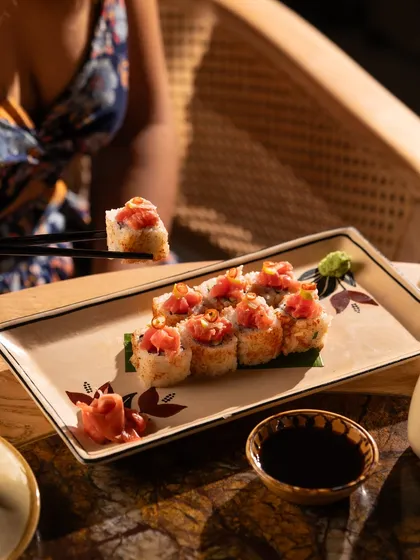 A lifestyle shot of someone enjoying sushi. This helps customers picture themselves at the restaurant, enjoying the food.