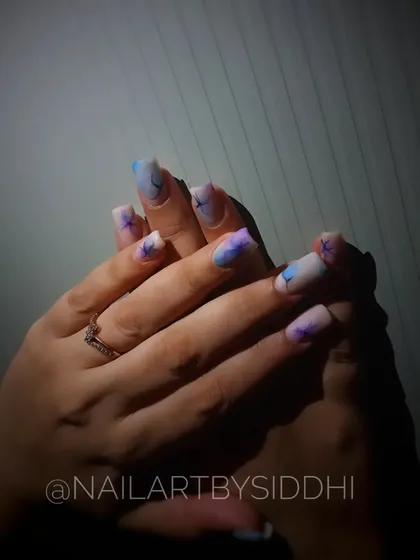 The full set of watercolor floral nails, showing the ethereal design across both hands.