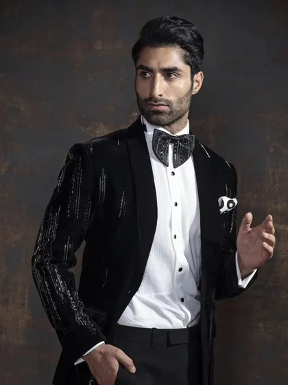 A closer look at the sequined tuxedo, showing the intricate detail and the way it catches the light. It’s paired with a patterned bow tie for an extra layer of personality.